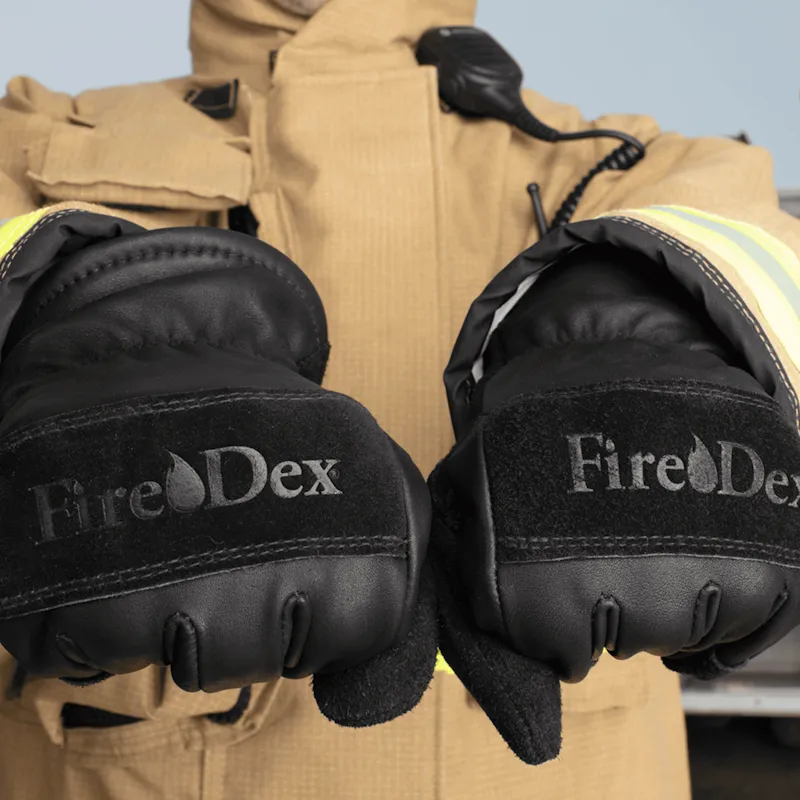 Close-up of a firefighter wearing and displaying a pair of Fire-Dex® Dex-Pro NFPA 1971 Structural Firefighting Gloves, emphasizing fit, dexterity, and protective features.