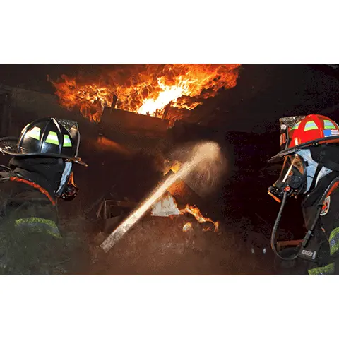 Two firefighters wearing Fire-Dex® H41 Interceptor with STEDAIR® Prevent jackets, with one actively hosing down burning materials, highlighting thermal protection, mobility, and reflective safety features.