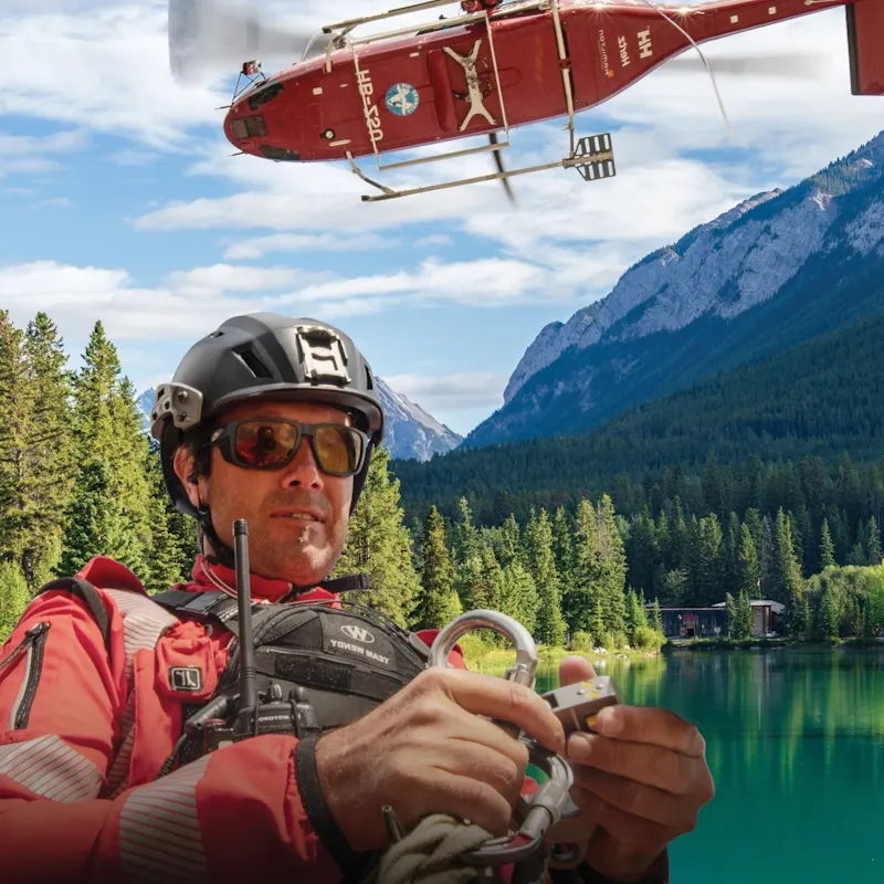 Team Wendy® SAR™ Backcountry Helmet worn by a mountain rescue worker during helicopter search and rescue operations in a rugged alpine wilderness environment.