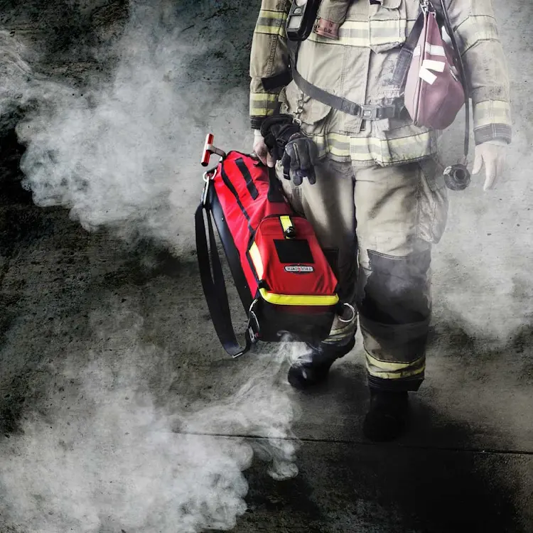 Close-up of firefighter carrying True North Gear L-3 Lite Speed™ RIT Bag showing padded straps, reflective tape, and rugged bag material during emergency response.