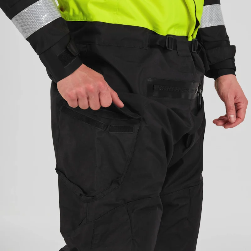 Closeup of a man wearing the NRS Ascent SAR Dry Suit in safety yellow with hands in pockets, highlighting the waterproof pocket design and suit fit.
