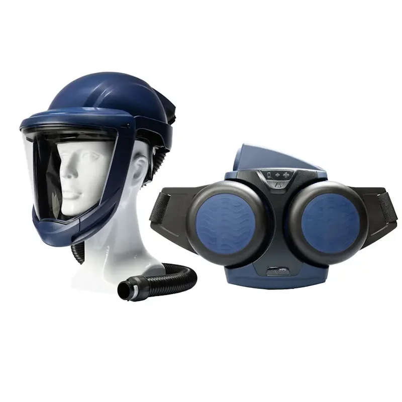 Sundström® SR 500/SR 580 powered air purifying respirator system in navy blue, featuring a hard-hat style headtop with a clear full-face visor and breathing hose on a mannequin head beside the belt-worn blower unit with dual round filters and adjustable waist straps.