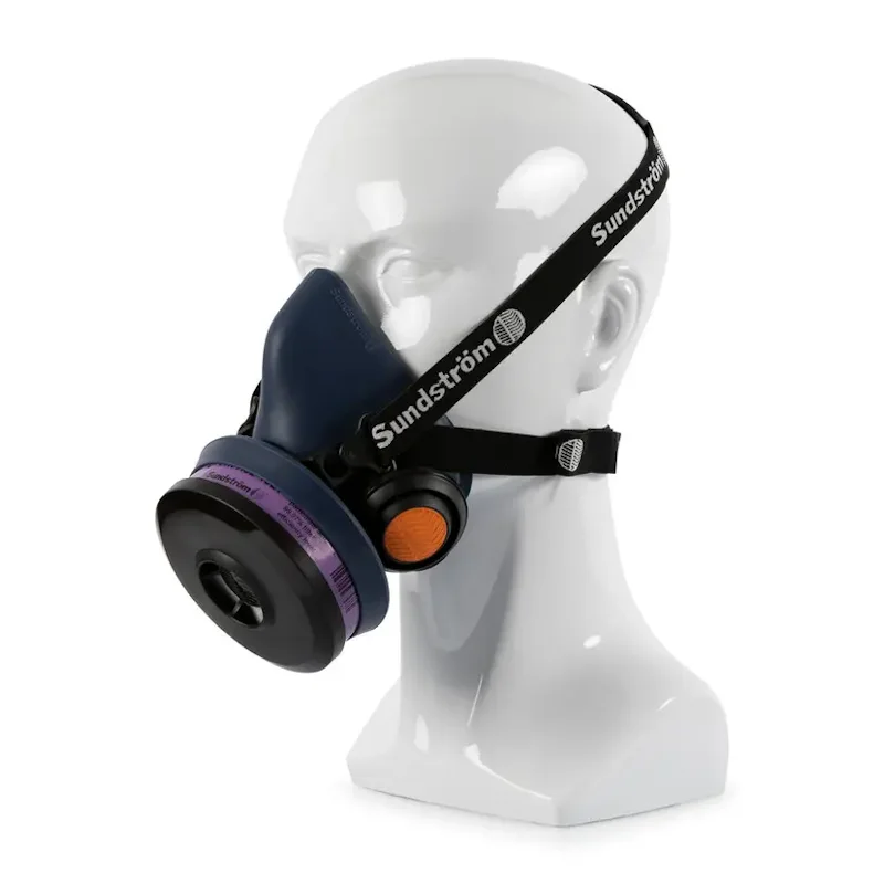 Sundström® SR 100 M/L half mask respirator with a navy blue silicone facepiece, shown on a mannequin head with black adjustable head straps, a purple-banded filter cartridge on the side, and an orange exhalation valve cover.