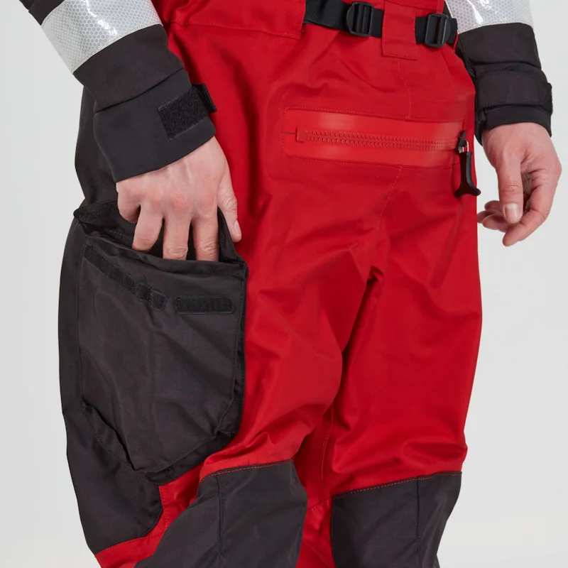 Closeup of a man wearing the NRS Extreme SAR GTX Dry Suit in red with hands in pockets, highlighting the waterproof pocket design and fit.