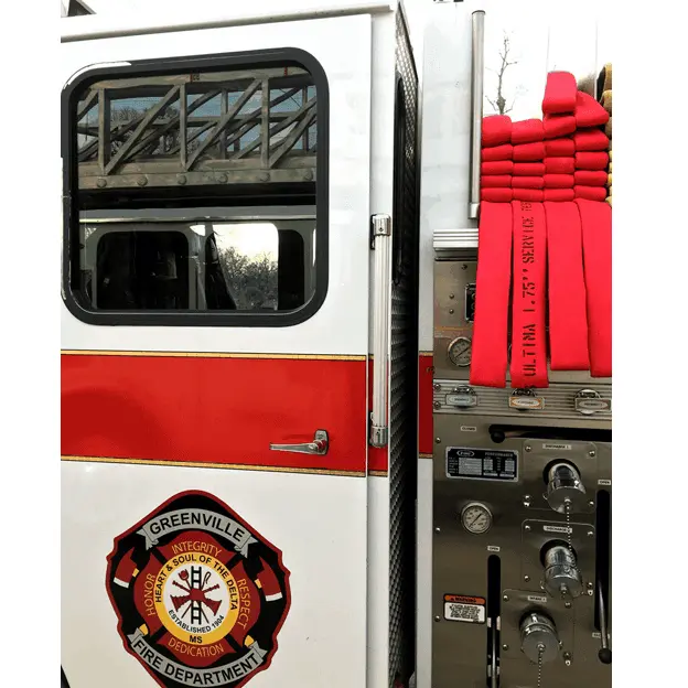 Closeup of the side of a firetruck showing multiple folded BullDog™ Ultima™ Firefighting Hoses neatly stacked on top, highlighting their compact storage and readiness for rapid deployment.
