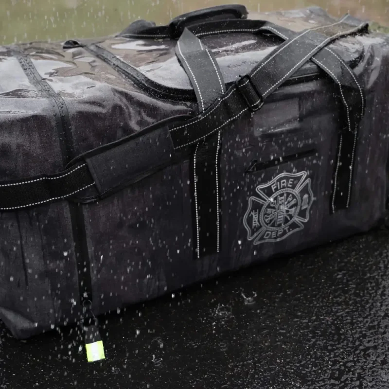 Front side view of Lightning X LXFB99 Carcinogen Resistant Dry Turnout Bag outside in the rain, demonstrating water-resistant features.