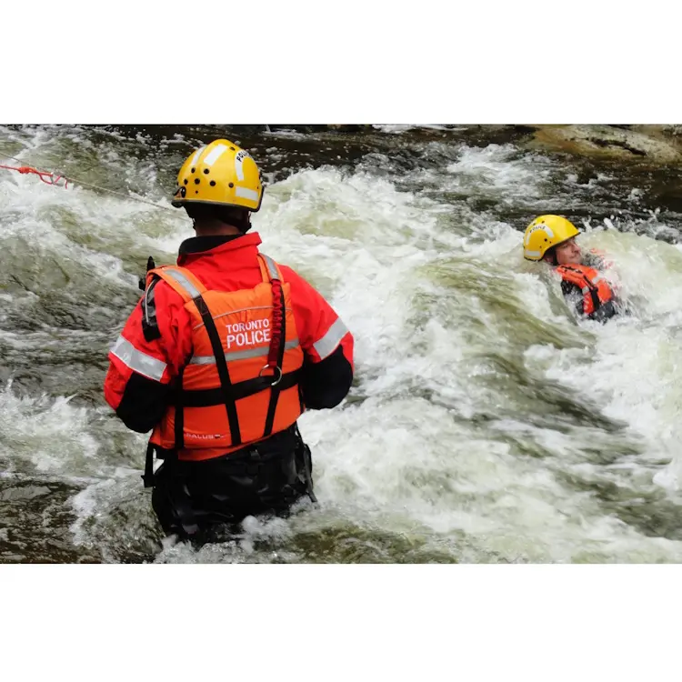 Policeman wearing Salus Marine SAR-770 Technician Vest while performing rescue operations in a river, showcasing durability and functionality in water environments.