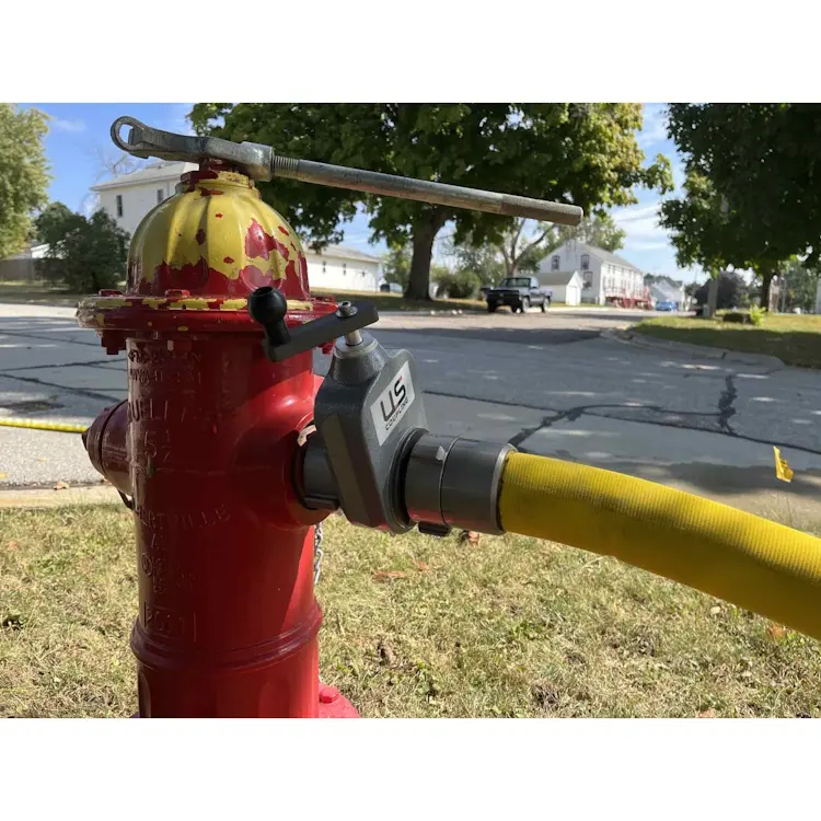 Closeup of a fire hydrant with BullDog™ Ultima™ yellow firefighting hose securely attached, highlighting the durable coupling and vibrant hose color for visibility.
