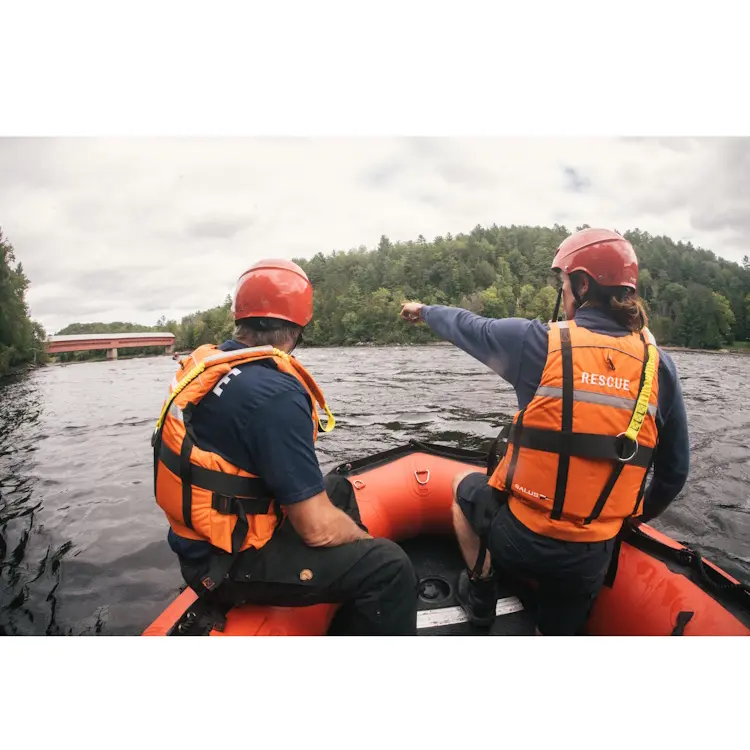 Two policemen aboard a rescue boat wearing Salus Marine SAR-770 Technician Vests, equipped for marine patrol and emergency response.