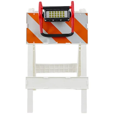 Red Streamlight® Portable Scene Light II with a black 18-LED panel mounted on top of a white road barricade with orange and reflective white diagonal stripes, shown as a warning light for roadway work zones.