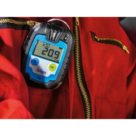 Dräger Pac® 6000 Single-Sensor Gas Detector clipped to a red coverall, displaying an oxygen reading of 20.9 percent.