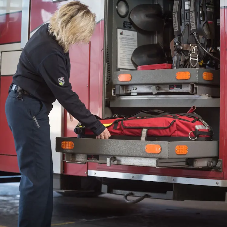 True North Gear L-3 Lite Speed™ RIT Bag stored on a sliding tray in the back of a fire truck, ready for rapid deployment during emergency rescue operations.