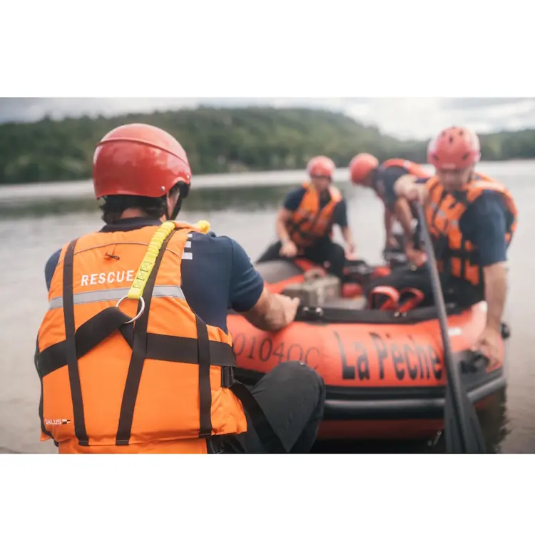 Multiple policemen wearing Salus Marine SAR-770 Technician Vests aboard a rescue boat being pulled onto land after a marine operation, highlighting durable safety gear in active use.