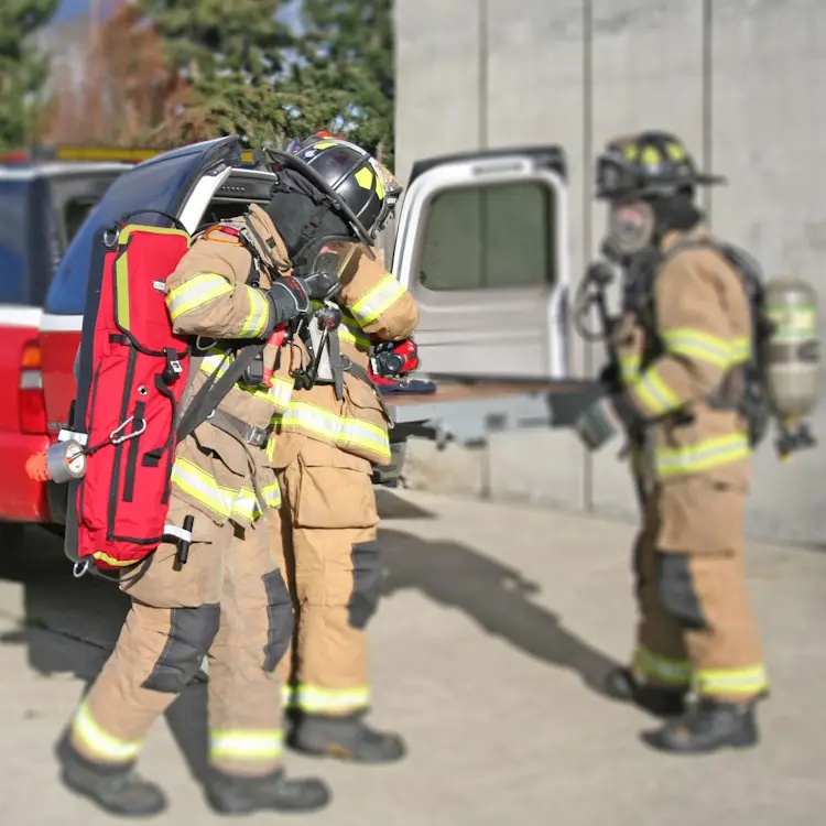 Firefighter carrying True North Gear L-3 Lite Speed™ RIT Bag equipped with padded straps and reflective tape, prepared for rapid intervention team operations.