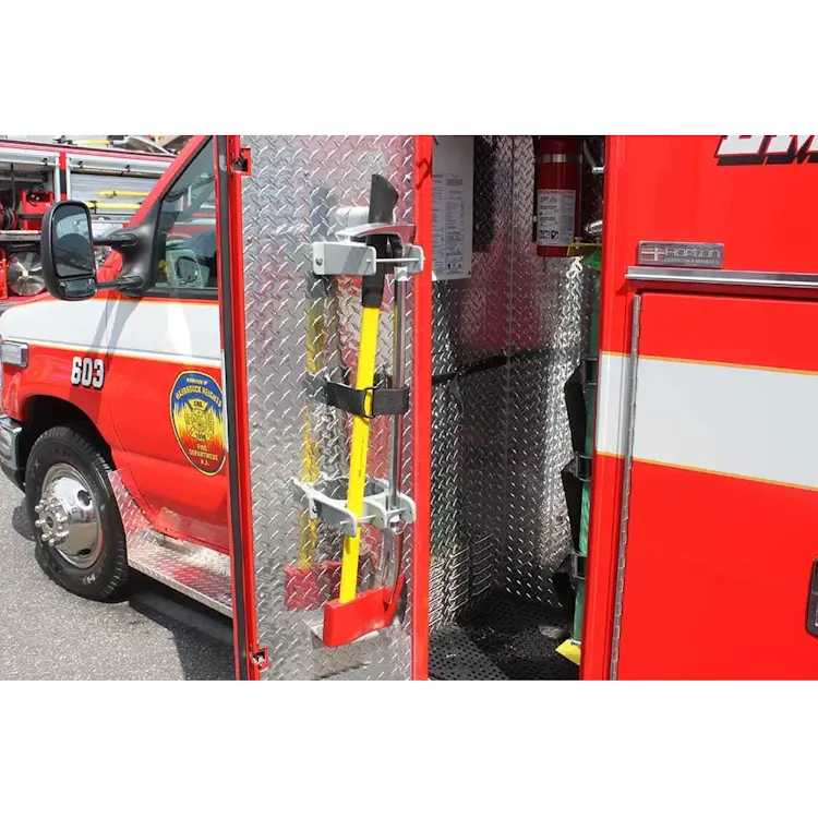 Ziamatic™ QUIC-BAR/Axe Mounting Bracket with Stop securely holding an axe mounted inside the door of a firetruck, providing safe and accessible storage for rapid deployment during emergency response.
