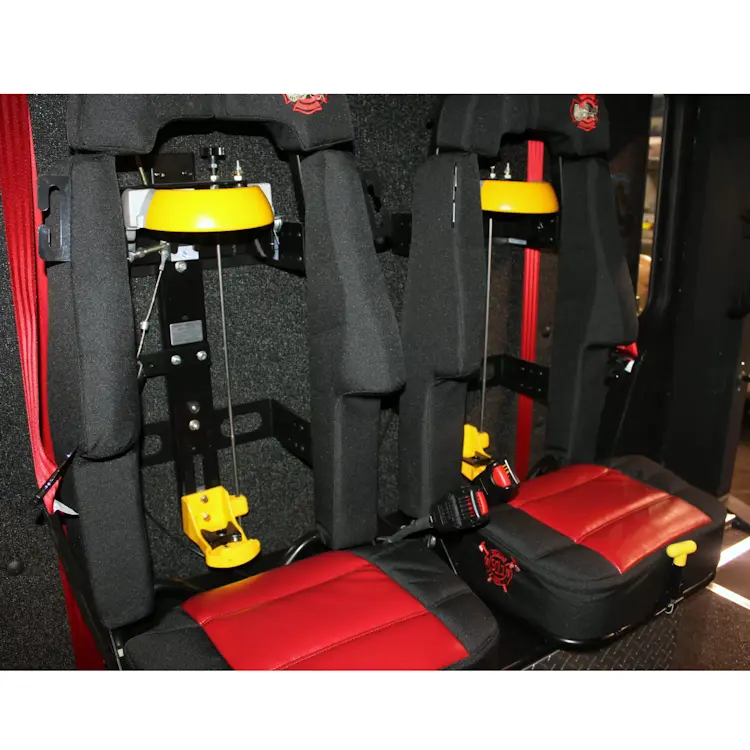 Two empty Ziamatic™ QUIC-LOCK Mechanical SCBA Brackets mounted on firetruck seats, ready to securely hold self-contained breathing apparatus (SCBA) cylinders for quick access during emergencies.