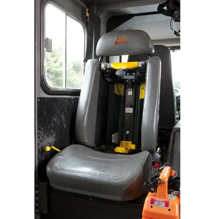 Empty Ziamatic™ ROL-LOC Mechanical Bracket mounted on a firetruck seat, ready to securely hold a cylinder for quick access during emergency response.