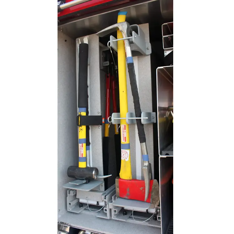 An axe securely held on the side of a firetruck by a Ziamatic™ QUIC-BAR/Axe Mounting Bracket with Stop, ensuring safe and accessible storage for rapid deployment during emergency response.