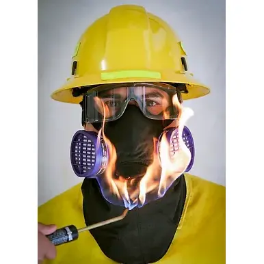Front view of a person wearing the Hot Shield® HS-5 Respirator Housing and Face Protector Mask over the Dräger Xplore 3500 respirator, demonstrating the mask’s heat-resistant properties as a flame is applied to its surface without damage or compromise.