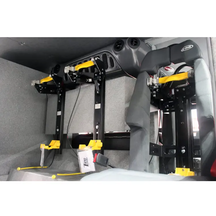 Three empty Ziamatic™ ROL-LOC Mechanical Brackets—two mounted together and a third next to them—installed on a firetruck seat, all ready to securely hold cylinders for emergency response.