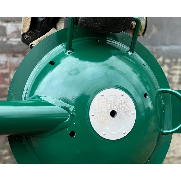 Close-up of the green dome-shaped Turtle Fire Systems™ EV Nozzle showing the engraved metal plate and carry handles.