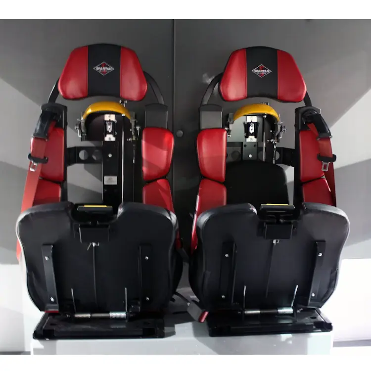 Two empty Ziamatic™ EZ-LOC Mechanical Brackets with Fixed Top Clamps mounted on firetruck seats, ready to securely hold cylinders for rapid access during emergencies.