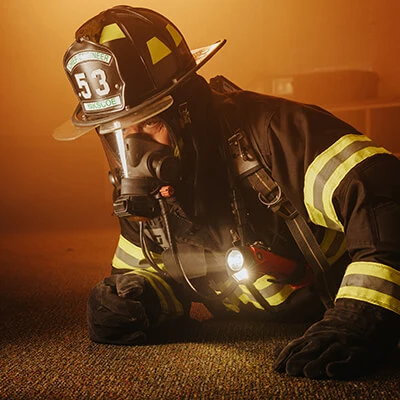 Streamlight® Survivor Pivot® flashlight in use by a firefighter, delivering reliable hands-free illumination during emergency operations.