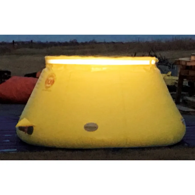 Yellow Husky® self-supporting frameless portable water tank with an illuminated upper rim glowing at dusk.