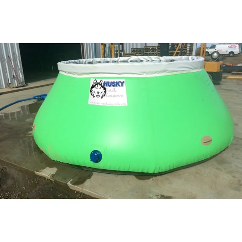 Green Husky® self-supporting frameless portable water tank with a gray upper collar and blue side outlet on a concrete pad.