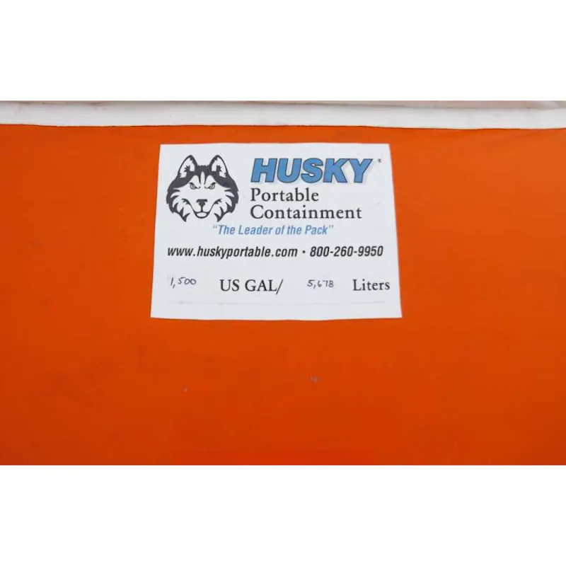 Close-up of the Husky® Portable Containment label on an orange self-supporting frameless portable water tank showing a 1,500 US gallon capacity.