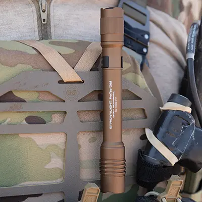 Light brown Streamlight® ProTac® 2AA Flashlight attached to a backpack strap, showcasing its compact design and portability.