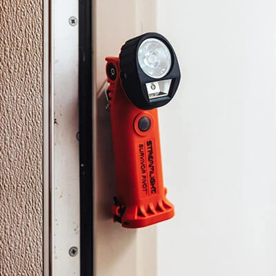 Streamlight® Survivor Pivot® flashlight hanging on a wall using its magnetic clip for convenient hands-free storage and quick access.
