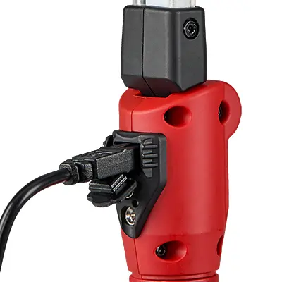 Back view of the Streamlight® Strion Switchblade® flashlight plugged into its charger, illustrating the rechargeable battery system for reliable power during tactical and emergency use.