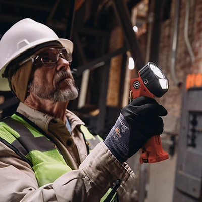 Streamlight® Survivor Pivot® flashlight in use by a worker indoors, providing hands-free illumination for safe and efficient tasks.