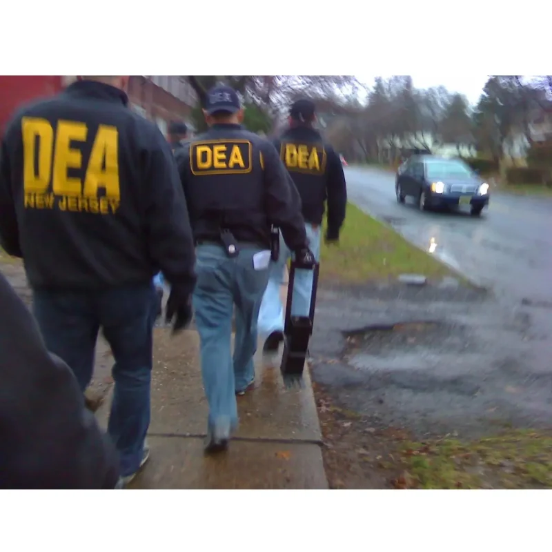 DEA agent holding the JTC Jersey Boot heavy-duty ram tool, featuring its solid steel construction and angled foot designed for powerful breaching and forcible entry.