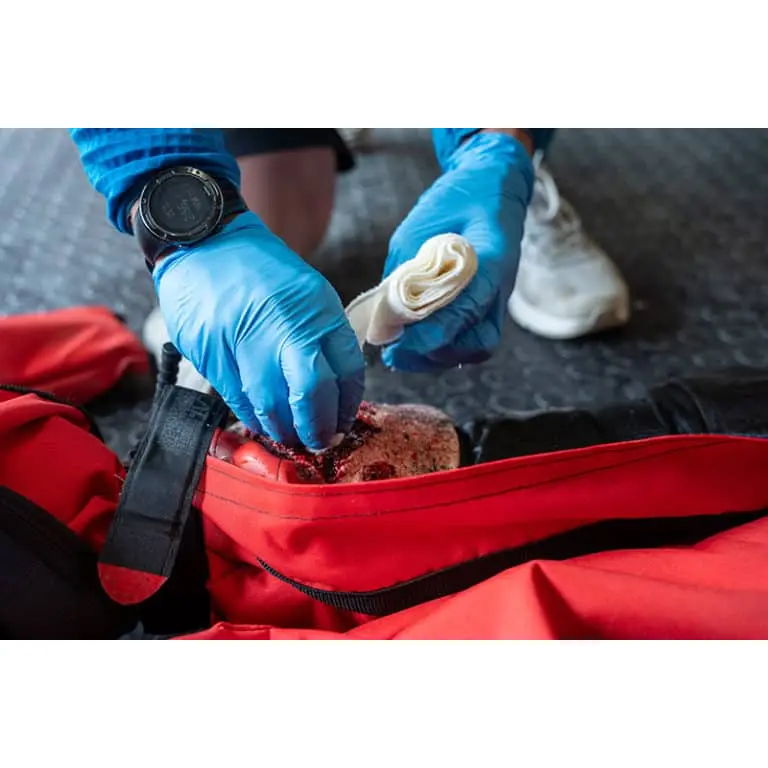 Ruth Lee™ Trauma Rescue Manikin having a simulated wound treated during a hands-on emergency response training exercise.