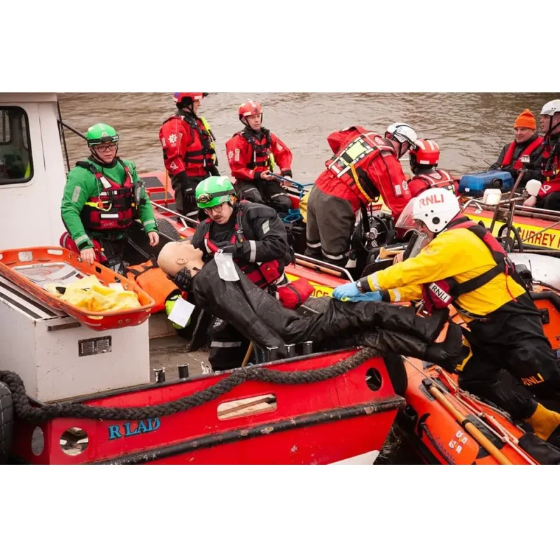 A Ruth Lee™ Advanced Water Rescue Manikin being transported off a boat by a rescue team during a simulated water rescue training exercise.
