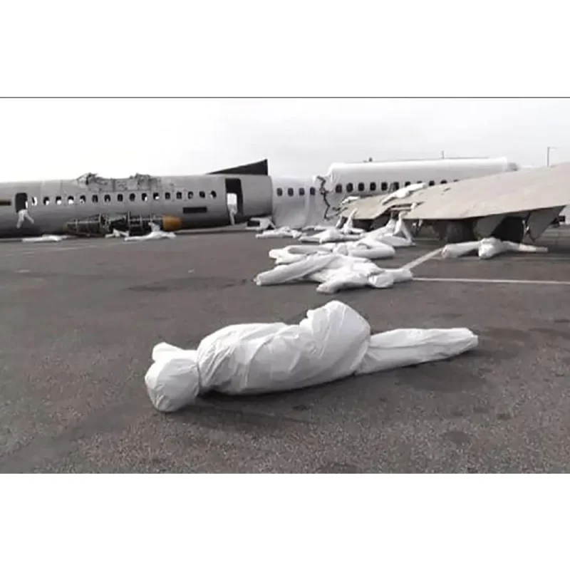 Multiple Ruth Lee™ Mass Casualty Training Manikins wrapped and lying on the ground outside a simulated airplane crash site, used for realistic multi-victim disaster and emergency response training.