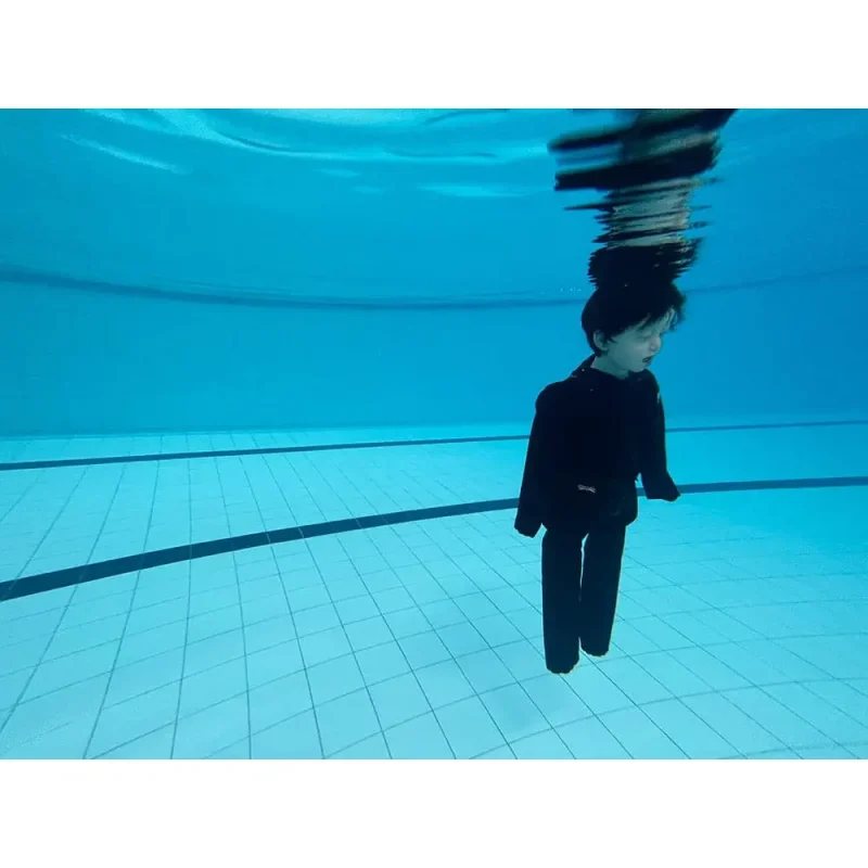A Ruth Lee™ Advanced Water Rescue Toddler manikin floating underwater in a pool, used for realistic submersion and rescue training scenarios.