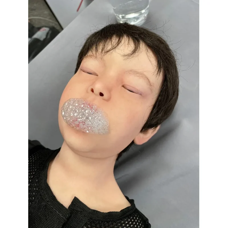 Close-up of the head of a Ruth Lee™ Advanced Water Rescue Toddler manikin with foam coming from the mouth, simulating drowning symptoms for rescue training.