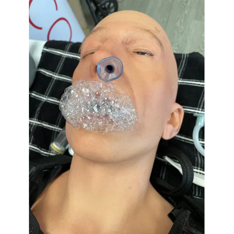 Close-up of the head of a Ruth Lee™ Advanced Water Rescue Manikin with foam coming from the open mouth, simulating realistic drowning symptoms for rescue training.