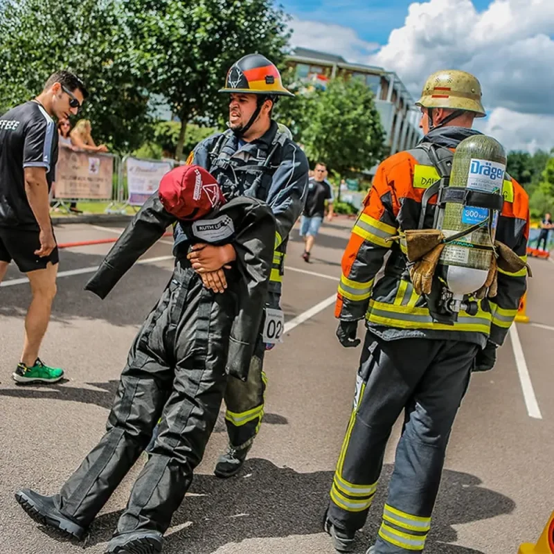 A Ruth Lee™ Duty Training Manikin is being carried by a firefighter during a rescue training exercise, simulating realistic emergency response conditions.