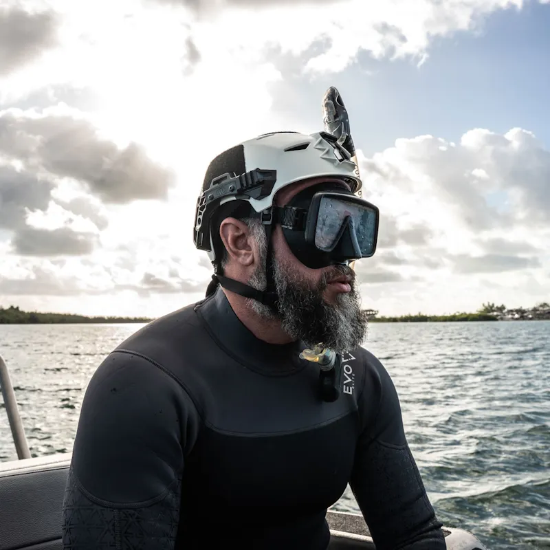 Diver wearing Team Wendy® EXFIL® Maritime Rescuer Bump Helmet in white with dive mask on boat near water.
